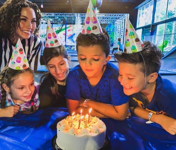 kids blowing out candles at a birthday party at trampoline park